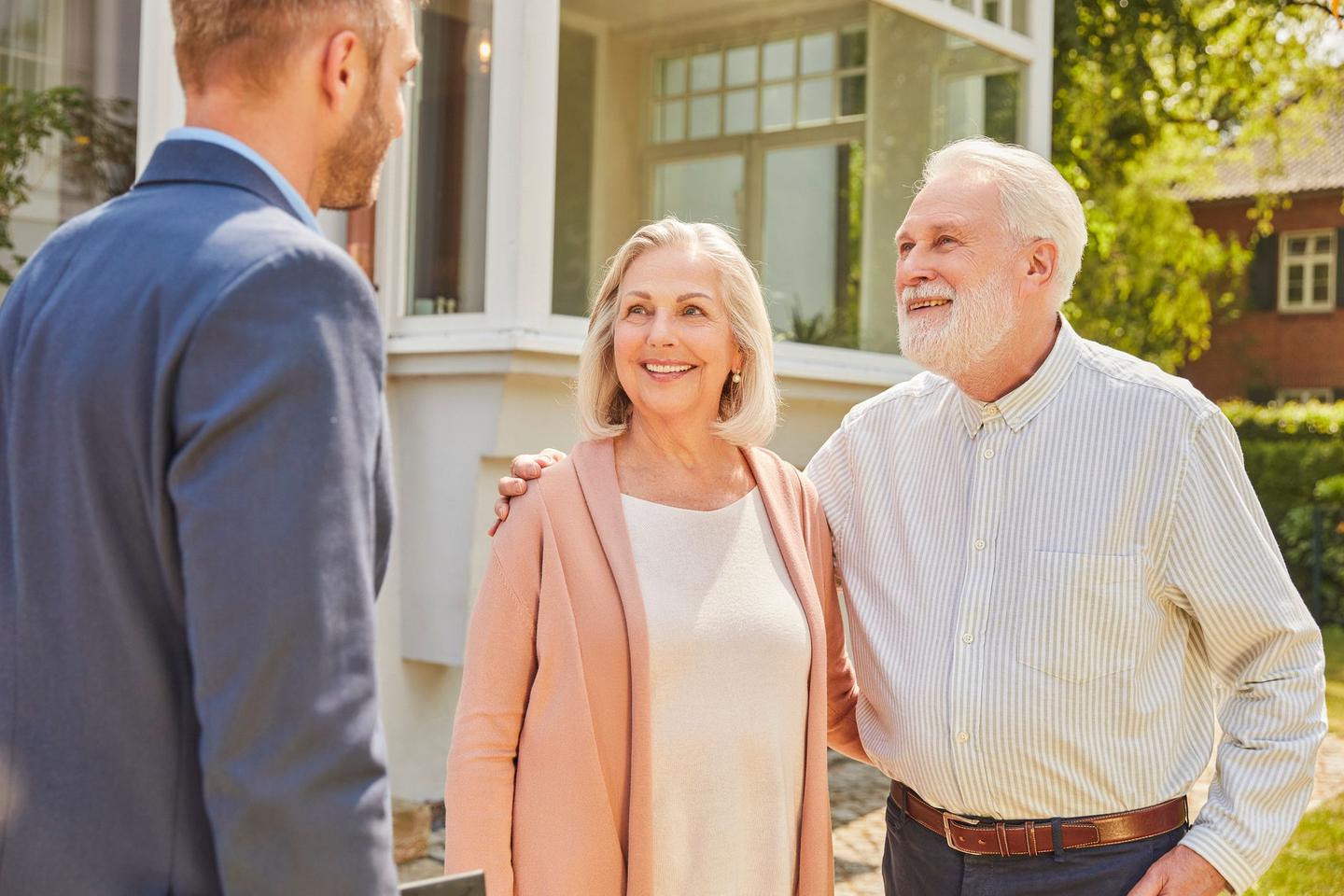 Berater mit Ehepaar vor Haus